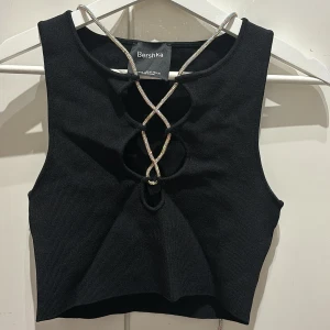 Topp med strassnörning - En supertjusig topp men en strassnörning runt halsen perfekt till nyår, som går att anpassa efter passform och smak. Använd 3 gånger. Den är kortare i modellen men passar super bra på mig som har S i storlek, väldigt stretchig i materialet. Fler bilder kan skickas 