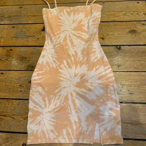 Kort klänning  - Kort tight batikmönstrad klänning från H&M Divided. Nästan oanvänd. Storlek xs. Strechig, liten slits nere. 