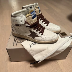Golden Goose Sky-Star sneakers - Snygga vita Golden Goose Sky-Star sneakers med bruna detaljer och snörning. Helt nya med tags. Ballstar fast höga. Kostar runt 6000kr i butik. Säljer för 2995. Hör av dig vid funderingar.