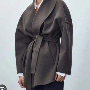 Grå  kappa med bälte - Hej jag undrar om det är någon som har denna kappa fast i M som vill byta mot min som är S? Är i nyskick! 