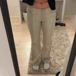 Beige bootcut kostymbyxor - Snygga beige bootcut kostym byxor med låg midja. Nästan aldrig använda men väldigt snygga då dem var för små! Jätte snygg passform