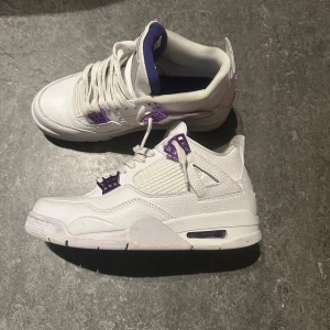 Jordan 4 metallic purple - Snygga vita Nike Air Jordans med lila detaljer. Skorna har en klassisk design med snörning och en bekväm passform. Perfekta för dig som vill ha en stilren look med en touch av färg. Pris kan diskuteras vid snabb affär