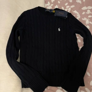 Svart ribbad tröja Polo Ralph Lauren - Säljer en stilren svart/mörkblå ribbad tröja från Polo Ralph Lauren helt oanvänd. 