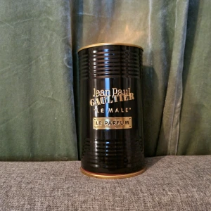 Jean Paul Gaultier Le Male Le Parfum - Säljer en elegant parfym från Jean Paul Gaultier, Le Male Le Parfum. Flaskan är formad som en manlig torso i svart med horisontella ränder och kommer i en stilren svart metallförpackning. Perfekt för den som vill ha en intensiv och maskulin doft.