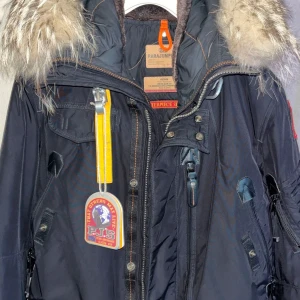 Parajumpers herr stl M - Snygg svart parkajacka från Parajumpers med pälsdetaljer på huvan. Jackan har flera fickor och en gul remdetalj vid dragkedjan. Perfekt för kalla dagar. Använt fåtal gånger.