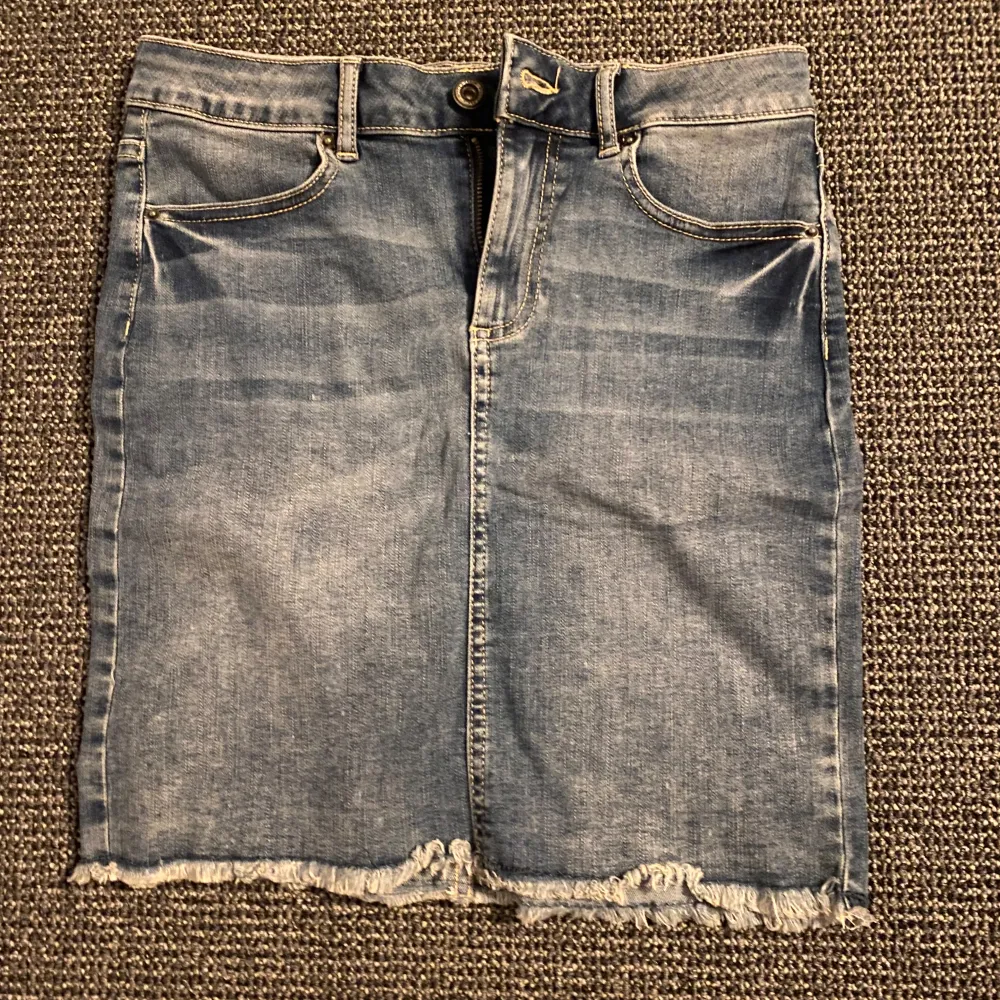 Snygg jeanskjol från Pieces i klassisk blå denim. Kjolen har en rak passform med fransig nederkant och femficksdesign. Knappast använd💕💕. Hameet.