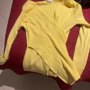 Gul ribbad kofta från Cherry Koko - Säljer en solgul ribbad kofta från Cherry Koko. Perfekt för vår och sommar med sin lätta och luftiga design. Koftan har långa ärmar och en öppen front som gör den enkel att matcha med olika outfits. Ett måste för garderoben! 🌼