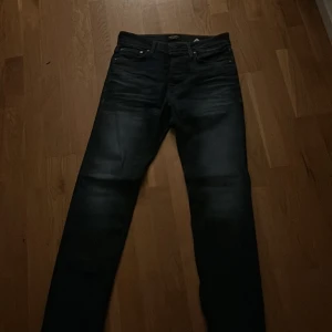 Mörkblå jeans från Jack & Jones - Snygga mörkblå jeans från Jack & Jones med klassisk femficksdesign och en läderpatch baktill. Jeansen har en straight passform och är perfekta för en stilren look. De har en knappgylf och kontrastsömmar som ger en extra touch. Och dom är aldrig använda eftersom dom är för stora för mig. Tveka inte att höra av er😀 om de är nå mer ni undrar är de bara att skriva mvh Filip😀