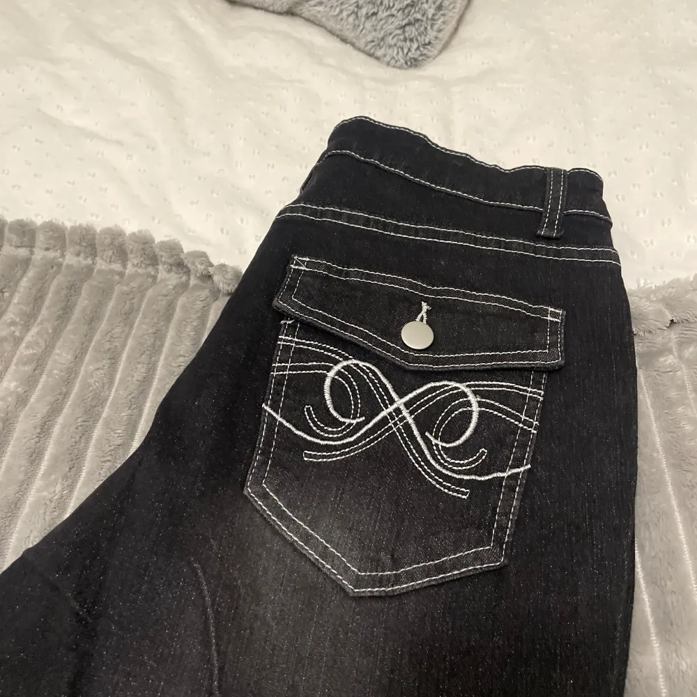 Snygga svarta jeansbyxor från Shein Curve med dekorativa bakfickor och kontrastsömmar. Byxorna har en bootcut-stil som ger en trendig look. . Farkut & Housut.