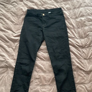 Svarta skinny jeans - Snygga svarta skinny jeans med knapp och dragkedja framtill. De har en klassisk femficksdesign och är perfekta för en stilren look. Passar bra till både vardag och mer uppklädda tillfällen.