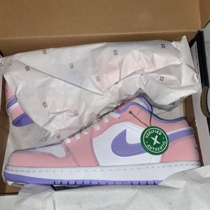 Jordan 1 - Snygga Jordan 1 i en fräsch kombination av rosa och lila. Skorna är i storlek US 8 för män men passar tjejer me. Perfekta för att ge din outfit en färgklick. Skorna är använda🤍