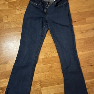 Blå jeans från John Baner - Snygga blå jeans från John Baner med klassisk femficksdesign och dragkedja. De har en bootcut-stil som ger en tidlös look. 