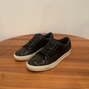 Lanvin Cap Toe UK 6 - Säljer dessa riktigt snygga och stilrena Lanvin Cap Toe i en mörkgrå/svart färg. Skick: 9,5/10 i otroligt fint skick och har blivit professionellt tvättade och impregnerade. Storlek UK 6 vilket motsvarar 40 men passar upp till 41,5. Nypriset på dessa ligger runt 5000. Inga byten! Hör av dig vid några funderingar!