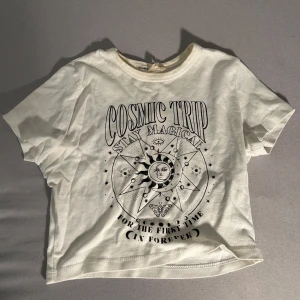 Croppad vit baby tee med tryck - Säljer en vit croppad T-shirt (baby tee) från Pull & Bear. Tröjan är nästan aldrig använd men har en svag missfärgning på innersidan utav hals ringen. Säljer eftersom den inte är min stil längre men passar perfekt till sommaren! Kontakta mig för mer information.🤍