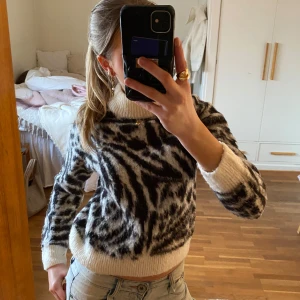 Zebramönstrad stickad tröja - Skit snygg och cool zebramönstrad stickad tröja med långa ärmar och ribbade muddar. Varm och skön, säljer då den blivit för liten. Tröjan är knappt använd och har inga defekter. 