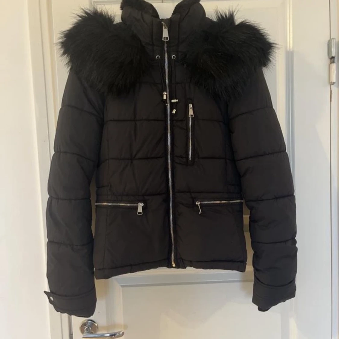 Svart dunjacka med pälsdetaljer från TRF