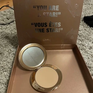 Airbrush Bronzer 1 Fair/Pale från Charlotte Tilbury - Lyxig bronzer från Charlotte Tilbury i en elegant guldskimrande förpackning. Perfekt för att skapa en solkysst look med en mjuk och jämn finish. Kommer i en stilren ask med spegel för enkel applicering.