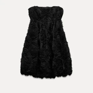 Svart klänning - Snygg helt ny svart axelbandslös klänning med  blomdetaljer. Helt slutsåld och nypris 599. XL men sitter mer som S. Prislappen e fyf kvar 