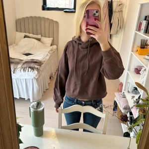 Brun hoodie - Säljer en brun hoodie med en fin passform. Den har en justerbar dragsko i huvan och ribbade muddar vid ärmslut och nederkant. Perfekt för en casual look.