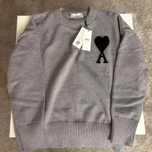AMI Paris tröja - Snygg och stilren grå tröja från AMI Paris. Riktig skön och snygg med bra kvalite. Tröjan har en klassisk design med rund hals. Den är sann i passform. Priset går att diskutera.