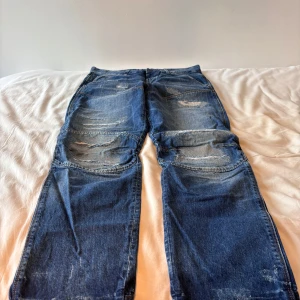  G-Star RAW jeans - Straight/flared jeans. Coola jeans från G-Star Raw med en sliten design! i mycket bra skick! storlek W33 L32. Skriv om du vill ha exakta mått! 