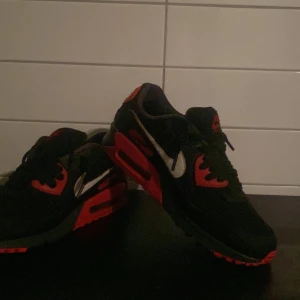 Nike Air Max i svart och röd - Säljer mina Nike Air Max 90. Skorna har en klassisk design med synlig luftdämpning i sulan och den ikoniska Nike-loggan i vitt på sidan. Köpte dem i slutet av december 2023 dem e ganska använda men är inget håller något sånt på dem köpte dem för 2000 kan medfölja box beroende på vad för pris som erbjuds skriv till mig om ni vill ha mer bilder