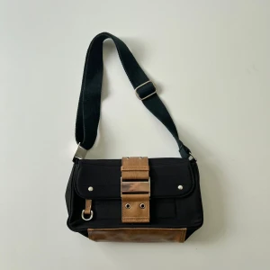 Handväska - Svart handväska med justerbar axelband så det går o ha som axelremsväska. Bredd: 25 cm. Djup: 7,5 cm. Höjd: 13 cm 🖤