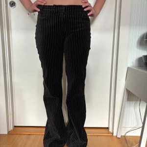 Randiga velour kostymbyxor - Svarta lågmidjade kostymbyxor med rosa ränder. Storlek 34/XS/S. Säljer då de inte sitter exakt som jag hade velat. 💗