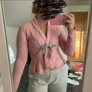 Rosa mönstrad kofta från Odd Molly - Säljer en superfin rosa kofta från Odd Molly med ett snyggt mönster. Den har långa ärmar och en söt rosett framtill. Perfekt för både vardag och fest! Koftan är i bra skick och gjord av bomull, vilket gör den både bekväm och stilren.