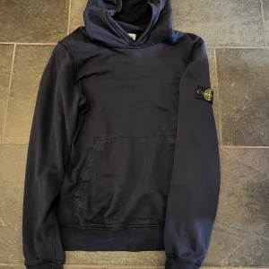 Stone island hoodie  - Stone island hoodie i storlek 170  Fint skick förutom ett litet hål på baksidan av armen men inget som syns vid användning 