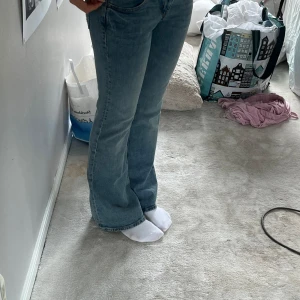 Utsvängda lågmidjade jeans - Ett par jätte snygga oanvända lågmidjade jeans i storlek 34. Coolt tryck på bakfickorna och helt oanvända. 