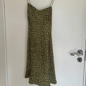 Leopardklänning - Säljer denna jättefina grönaklänning med leopardprint från zara. Banden är korsade i ryggen och den har en volang längst ner av klänningen. Säljer då den tyvärr är för liten för mig💕