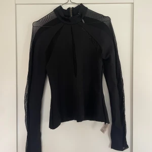 Svart topp med mesh detaljer - Jättesnygg svart topp som har meshdetaljer längs framsidan armarna och nästan hela ryggen🖤Spandex är en del av materialet därav väldigt skön. Hittar ingen storlek men passar stl S (även M). Avklippt nertill så den enklare gick att stoppa in.