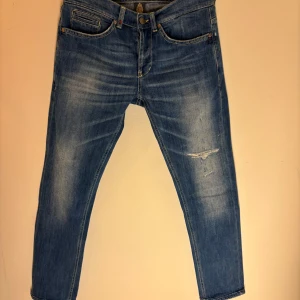 Dondup George w32 - Snygga blå jeans från Dondup med en lätt slitning på framsidan. De har en klassisk femficksdesign och en knappgylf. Tillverkade i Italien, dessa jeans har en modern look med en bekväm passform. Toppen skick utan defekter passar 170-180cm vikt spelar ingen roll.