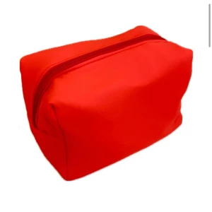 Röd/orange necessär - Snygg och praktisk röd necessär med dragkedja. Perfekt för att organisera dina toalettartiklar eller smink. Den kompakta designen gör den lätt att ta med på resor. Den har även en vaxduk på insidan för att förenkla rengöring!