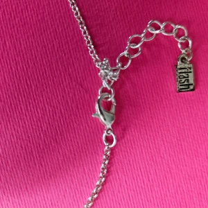 Silverfärgat halsband med hjärta - Elegant silverfärgat halsband med ett hjärta som hänge. Kedjan är tunn och smidig med en justerbar längd tack vare förlängningskedjan. Perfekt för att ge en subtil touch av kärlek till din outfit.