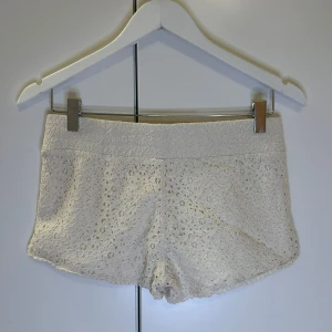 Vita spets shorts - Snygga vita shorts med spetsdetaljer. Perfekta för en somrig look med en bekväm passform. De har en elastisk midja och är gjorda i ett lätt material som andas.