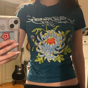  Ed Hardy T-shirt - Säljer en blå t-shirt från Ed Hardy med superfint tryck. Kommer tyvärr inte till användning. Använd då antal gånger. St S men passar mig som har xs. 