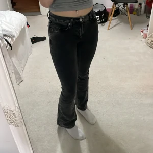 Svarta bootcut jeans - Snygga svarta bootcut jeans med medel midja. Perfekta för en stilren look. De har en klassisk femficksdesign och stängs med dragkedja och knapp. Passar bra till både sneakers och klackar.
