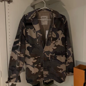 Camouflagejacka från Zadig & Voltaire - Säljer en cool camouflagejacka från Zadig & Voltaire i storlek XS men sitter som M. Jackan har en klassisk militärstil med flera fickor och en avslappnad passform. Perfekt för dig som vill ha en stilren och edgy look. Jackan är helt ny och säljes för 999kr