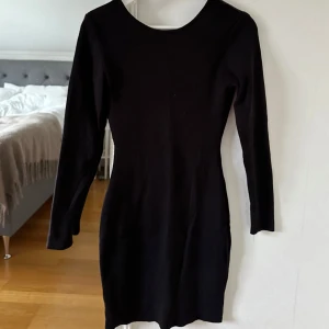 Svart Klänning - Säljer en kort svart stickad klänning med öppen rygg från Bubbelroom. Klänningen är figursydd som gör att den sitter superfint! Aldrig använd men tyvärr ingen prislapp kvar, nyskick. Storlek S. Nypris 500kr.