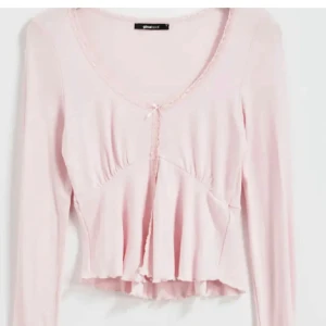 Rosa långärmad topp från Gina Tricot - Söt rosa långärmad topp från Gina Tricot med volangdetaljer och en liten rosett framtill. 