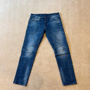 G-star raw biwes 3d slim jeans - Snygga blå jeansbyxor med en klassisk femficksdesign. Byxorna har en lätt slitning på knäna och en rak passform. Perfekta för en avslappnad stil.