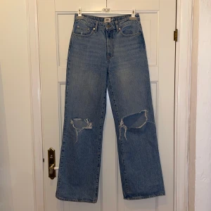 jeans  - Snygga blå jeans med hög midja och slitningar på knäna. De har en klassisk femficksdesign och raka ben. Perfekta för en avslappnad stil.