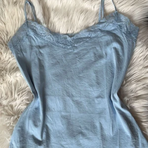 Ljusblå linne med spetsdetaljer - Ett ljusblått linne med smala och justerbara axelband med vacker spetsdetalj längs urringningen. Linnet är tillverkat i ett mjukt och bekvämt material! (Jag har vanligtvis strlk S-M)🩵