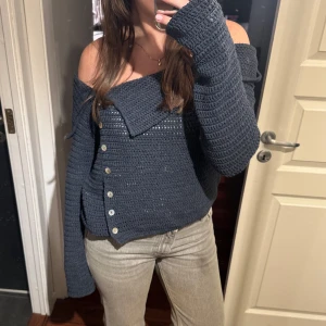 Marinblå stickad offshoulder tröja  - Säljer en snygg marinblå stickad offshoulder tröja från Zara i storlek L. Tröjan har långa ärmar och knappar framtill som ger en cool look. Perfekt att styla med jeans eller kjol. Tröjan är aldrig använd och har prislapp kvar🖤