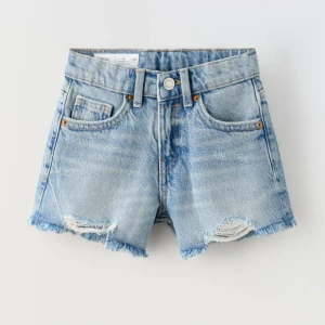 NYSKICK! Jeansshorts från zara  - Shorts i denim. Justerbar resårlinning. Knäppning med knapp på framdelen. Framfickor. Påsydd bakficka. Fransad nederkant. Shortsen är helt oanvända. 