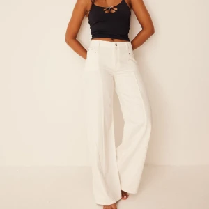 Vita vida byxor - Säljer ett par SUUPERsnygga vita jeans med mid waist och en vid passform. Perfekta för en stilren look, oavsett om det är till vardags eller fest. Byxorna har en klassisk design med knappar och dragkedja framtill. (Pris kommer vi överens om privat 🥰)