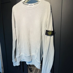 Vit tröja från Stone Island - Säljer en ljusgrå tröja från Stone Island i storlek L men den passar även M.  Tröjan är i bra skick och har inga skador. Priset är ej hugget i sten
