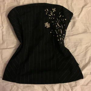 Tube top med pärlor  - En svart och vit randig tube top med pärlmönster på framsidan.